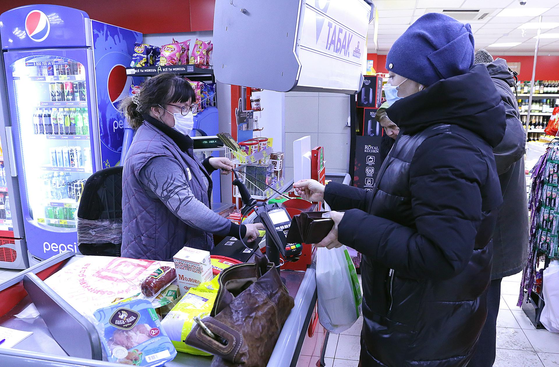 Кассир Виктория Колинько пробивает товары покупательнице Юлии Кагальницковой