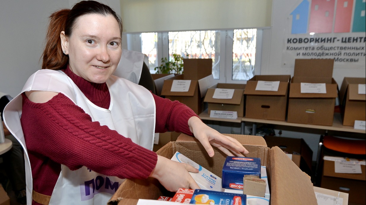 Волонтер Екатерина Лыжникова упаковывает муку для беженцев в пункте сбора помощи в ЮЗАО