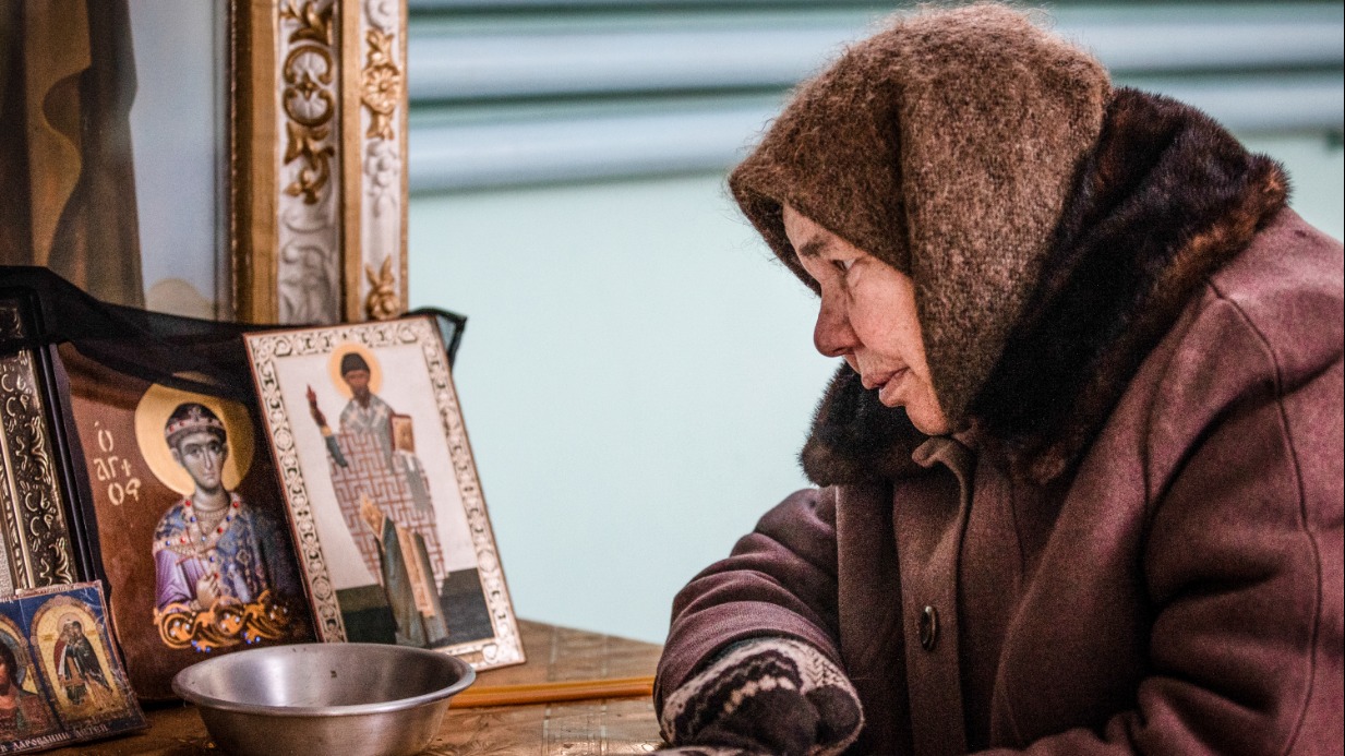 Луганская область. Жительница села Трехизбенка в Свято-Покровском храме. Не надо слов. Ветер донесет до весеннего неба тихую молитву: «...Чаю воскресения мертвых и жизни будущаго века. Аминь»