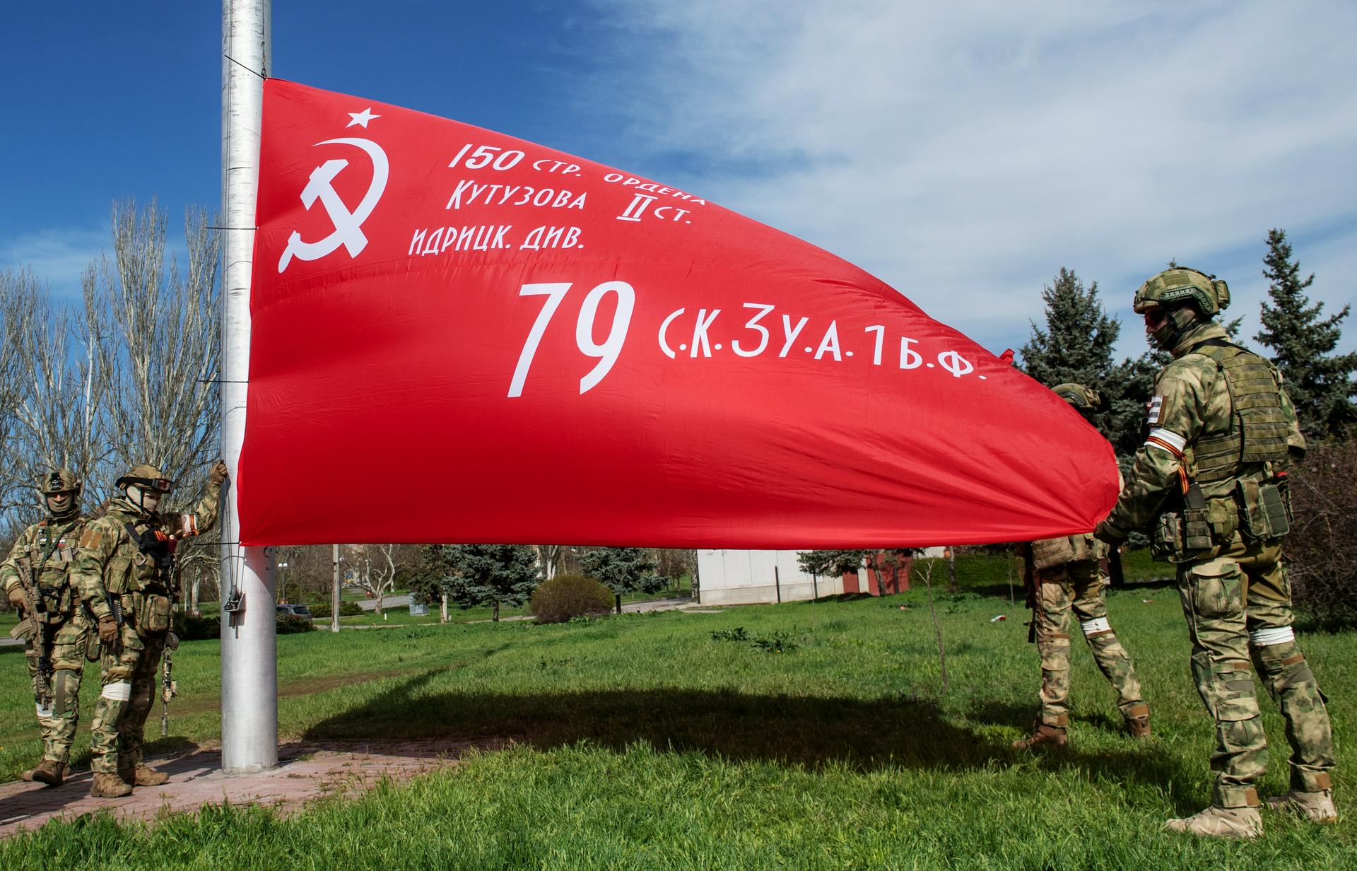 Росгвардейцы поднимают копию флага 150-й ордена Кутузова II степени Идрицкой стрелковой дивизии на аллее Славы в Херсоне