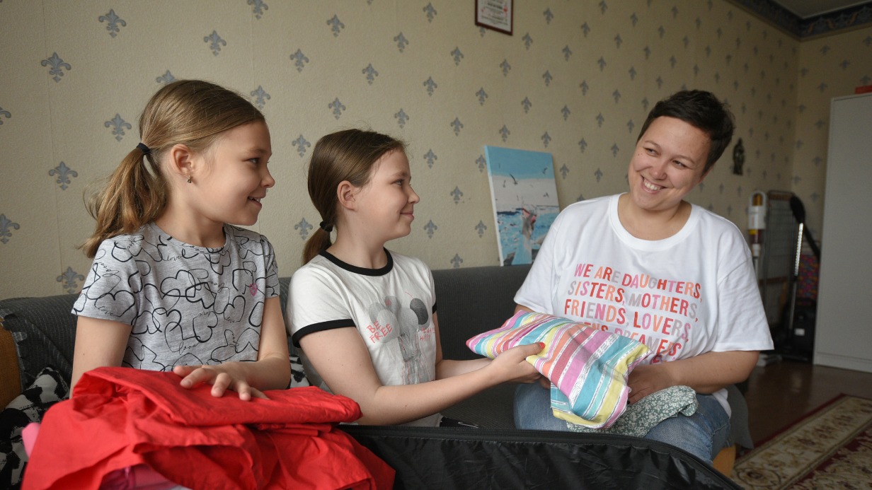 Мама Светлана Саранская собирает дочек Веронику (в центре) и Аришу в детский оздоровительный лагерь. Девочки поедут отдыхать в Подмосковье. С собой берут все самое необходимое: одежду, обувь, книги и игрушечного медведя-путешественника Гришу. Домой сестры вернутся через три недели