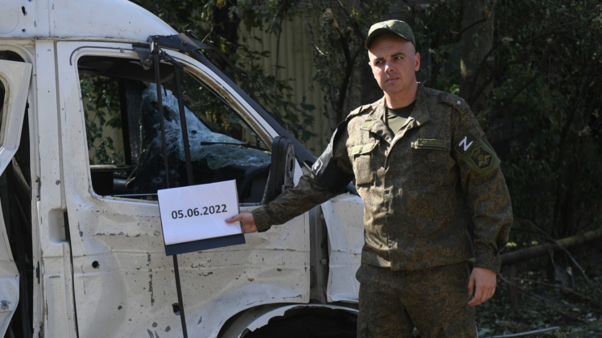 Военнослужащий Народной милиции ДНР рядом с автомобилем, который был поврежден в результате жестоких обстрелов Петровского района Донецка со стороны украинских националистов