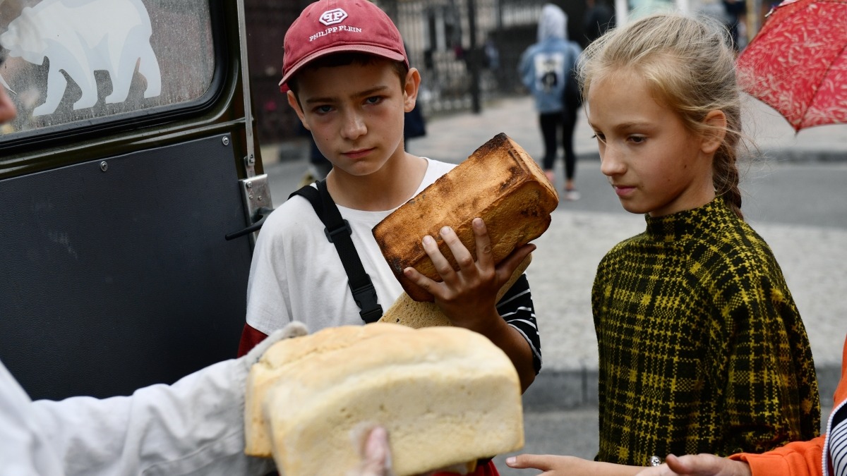 Дети стоят в очереди за хлебом у передвижного пункта гуманитарной помощи, оборудованного возле Покровского храма в Мариуполе. Туда доставили очередной груз с едой и другими необходимыми вещами