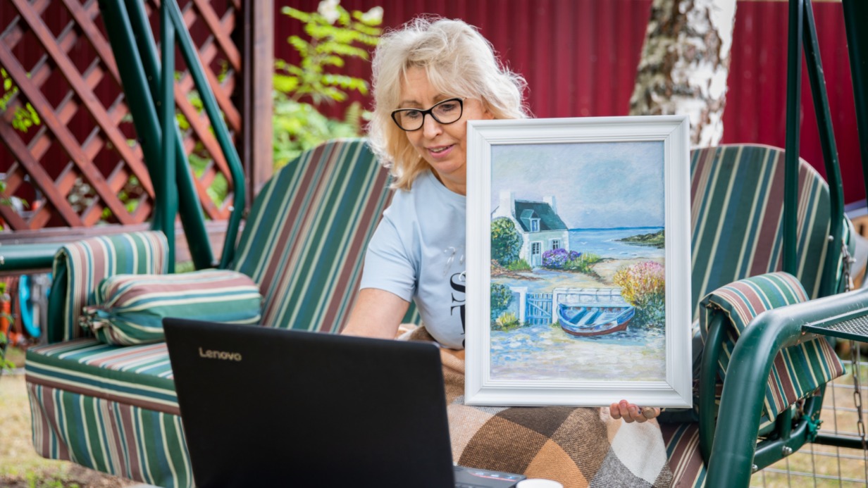 62-летняя Елена Болысова на онлайн-уроке по рисованию показывает написанную работу своему педагогу