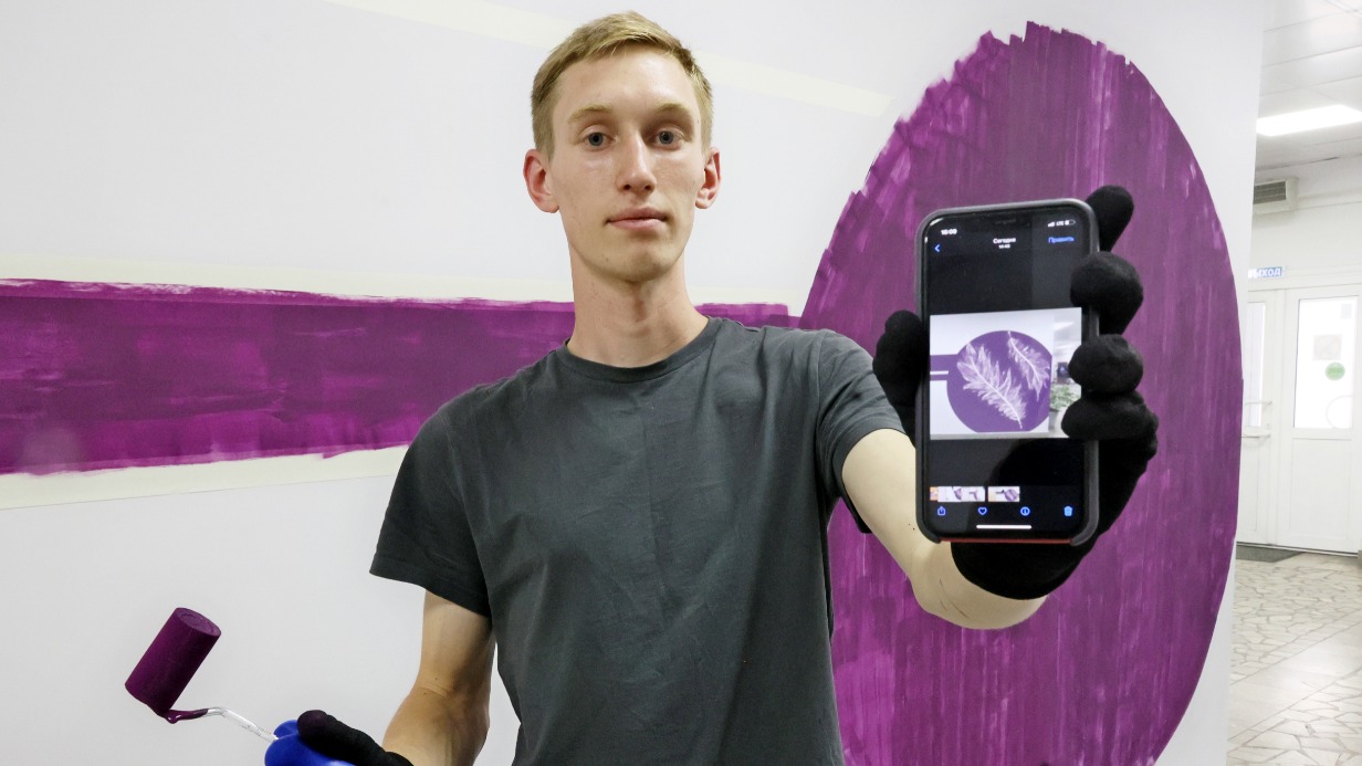 Художник-каллиграф Александр Абросимов показывает эскиз рисунка, который он переносит на одну из стен библиотеки № 51. Напротив появится написанный вязью портрет Анны Ахматовой. В изображении поэтессы художник зашифрует одно из ее стихотворений