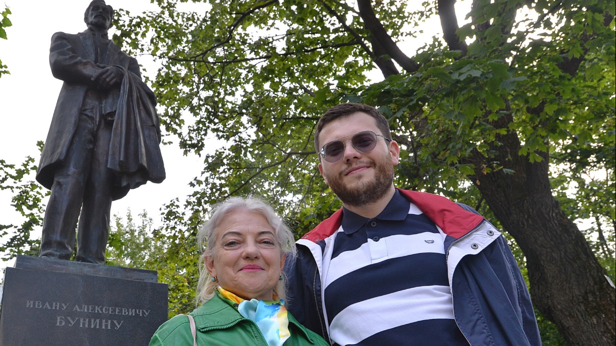Участники экскурсии «Философский Арбат» 65-летняя активистка программы «Московское долголетие» Елена Соболева с сыном Владимиром у памятника Ивану Бунину