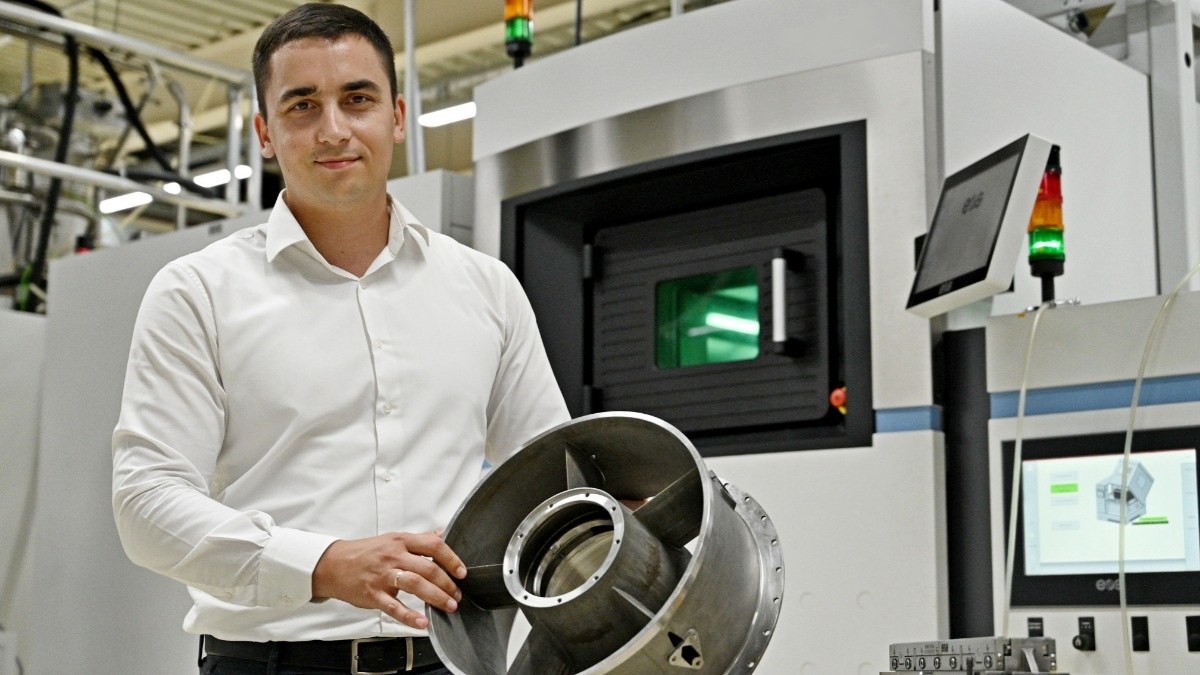 Руководитель группы аддитивного производства ЦАТ Михаил Жеребцов держит деталь наземного двигателя энергетической установки, которая напечатана на 3D-принтере. По такому же принципу в центре создают и элементы авиадвигателей