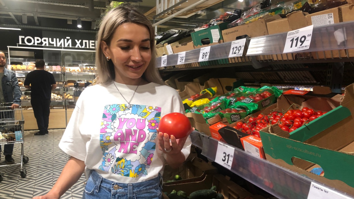 Москвичка Анастасия Воронина выбирает сезонные помидоры в овощном отделе одного из столичных сетевых супермаркетов