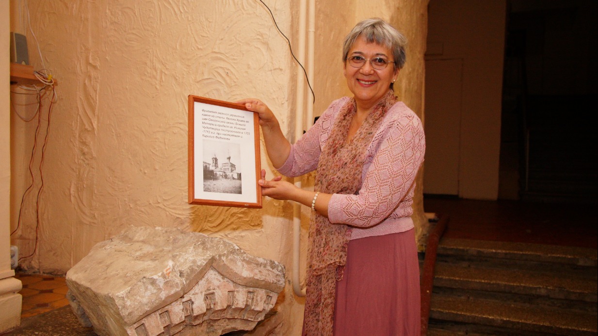 Прихожанка храма святителя Николая в Новой Слободе Наталия Королева показывает фрагмент камня, украшенного резьбой. Раньше он был частью стены храма, который стоял на месте современной постройки в 1703–1712 годах