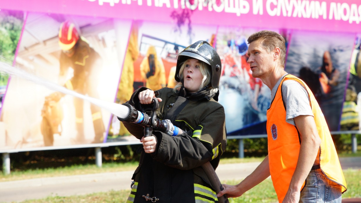 Школьница Виктория Ситникова вместе с инструктором Алексеем Каутером учится тушить пожар