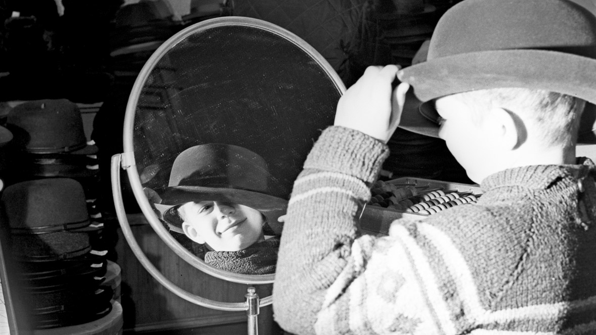 1967 год. К этому времени в Москве открылось большое количество различных торговых площадок, например, мальчик примеряет шляпу в столичном магазине «Богатырь»