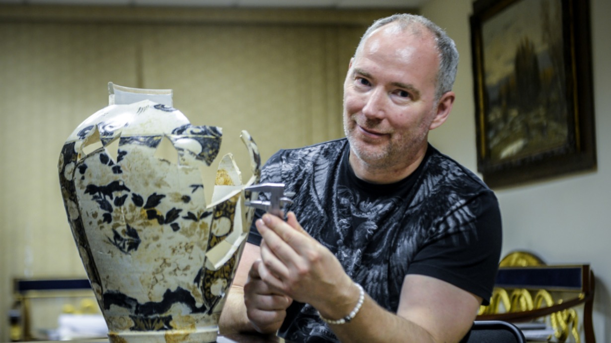 Археолог Константин Воронин демонстрирует реставрируемую вазу