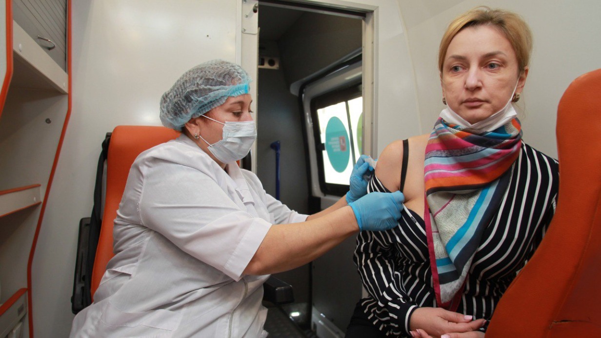 Медицинская сестра Инга Жиздан делает прививку от гриппа пациентке Елене Наумовой