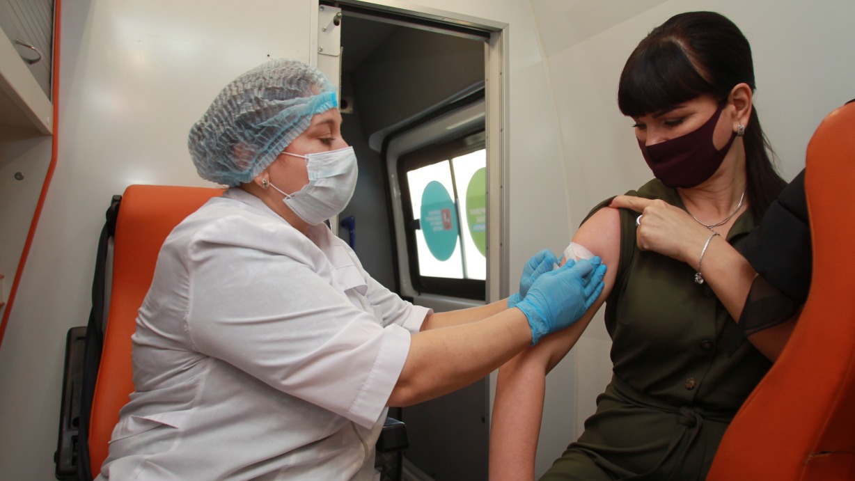 Медсестра Инга Жиздан делает прививку от гриппа пациентке Евгении Герасименко в одном из мобильных пунктов 