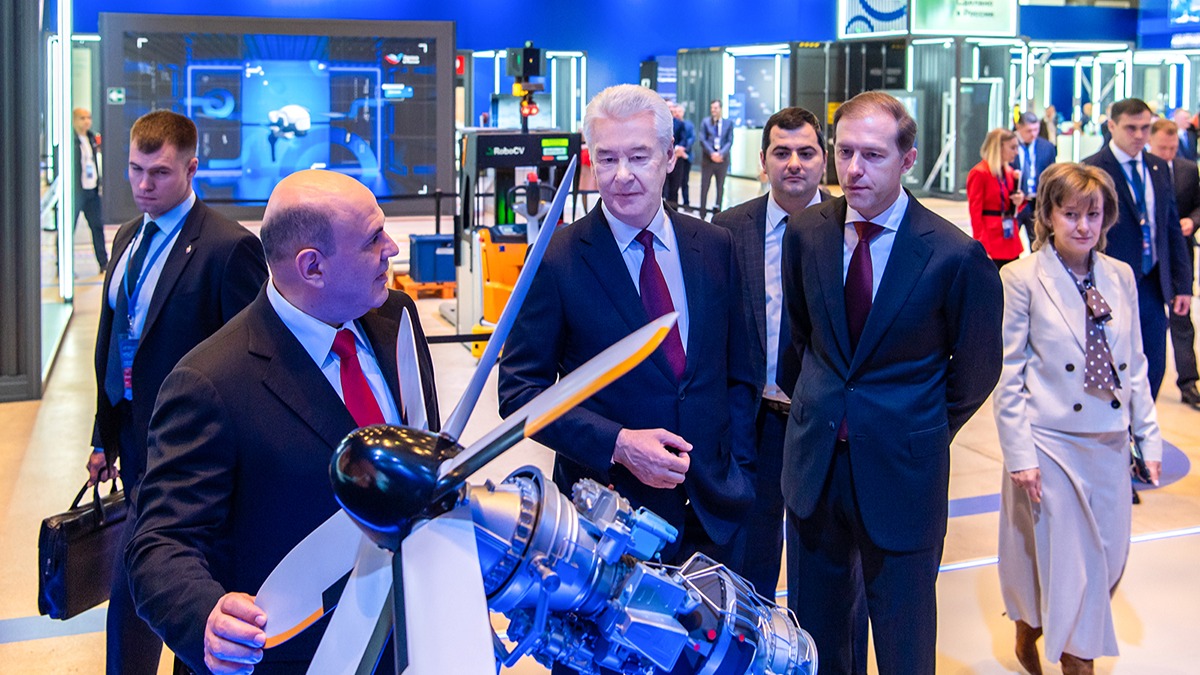 Мэр Москвы Сергей Собянин (в центре) на форуме «Сделано в России» показывает председателю правительства РФ Михаилу Мишустину (слева) и министру промышленности и торговли РФ Денису Мантурову (справа) макет турбовинтового двигателя, который производит один из столичных заводов