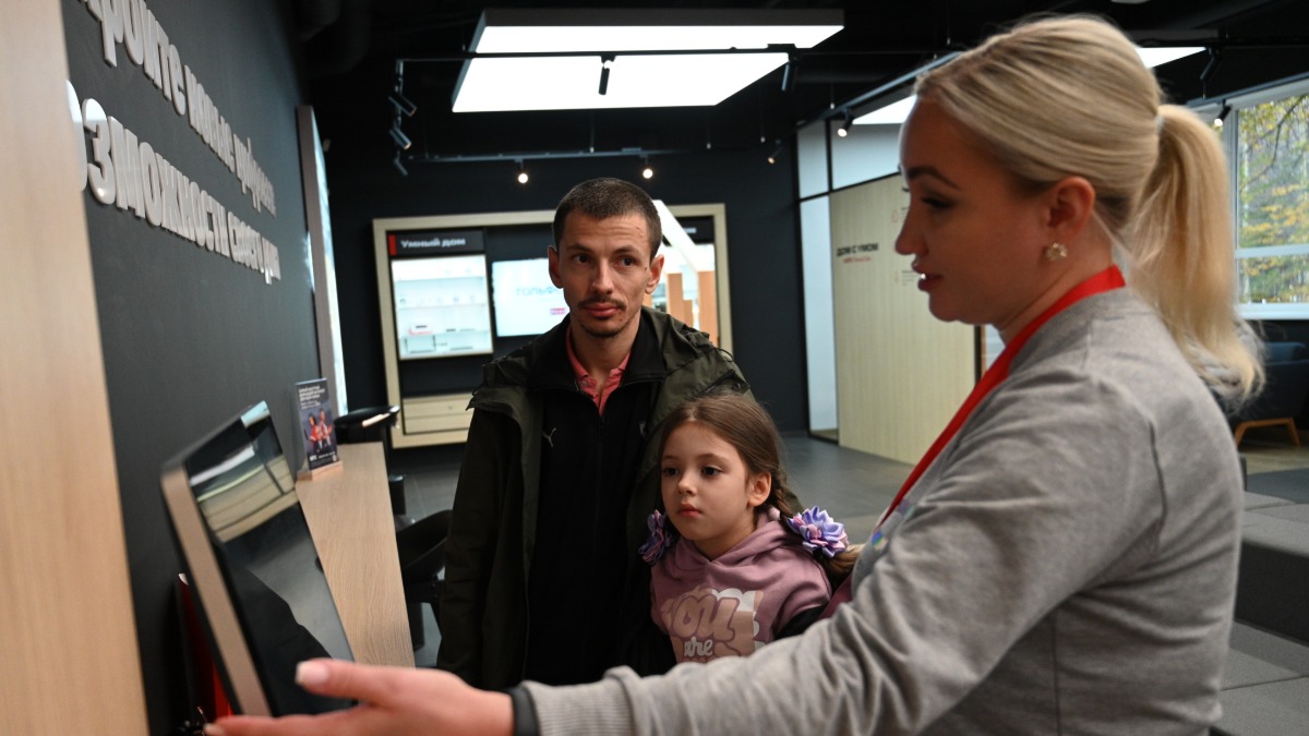 Старший менеджер компании Мария Заводчикова рассказывает посетителям о новых услугах