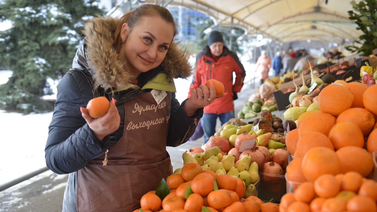 Продавец из Краснодарского края Нина Омельчинова на ярмарке выходного дня предлагает мандарины 