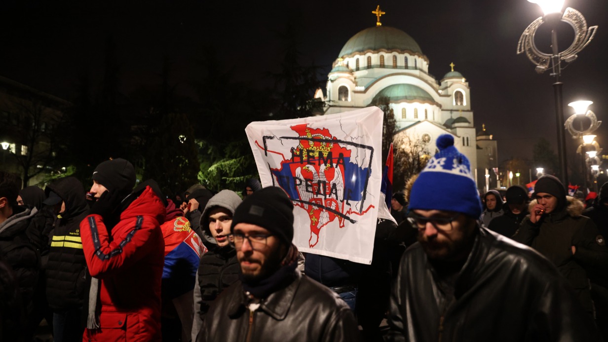 Протестующие маршируют с флагом с изображением карты Косова с надписью «Не сдаваться» во время акции в Белграде