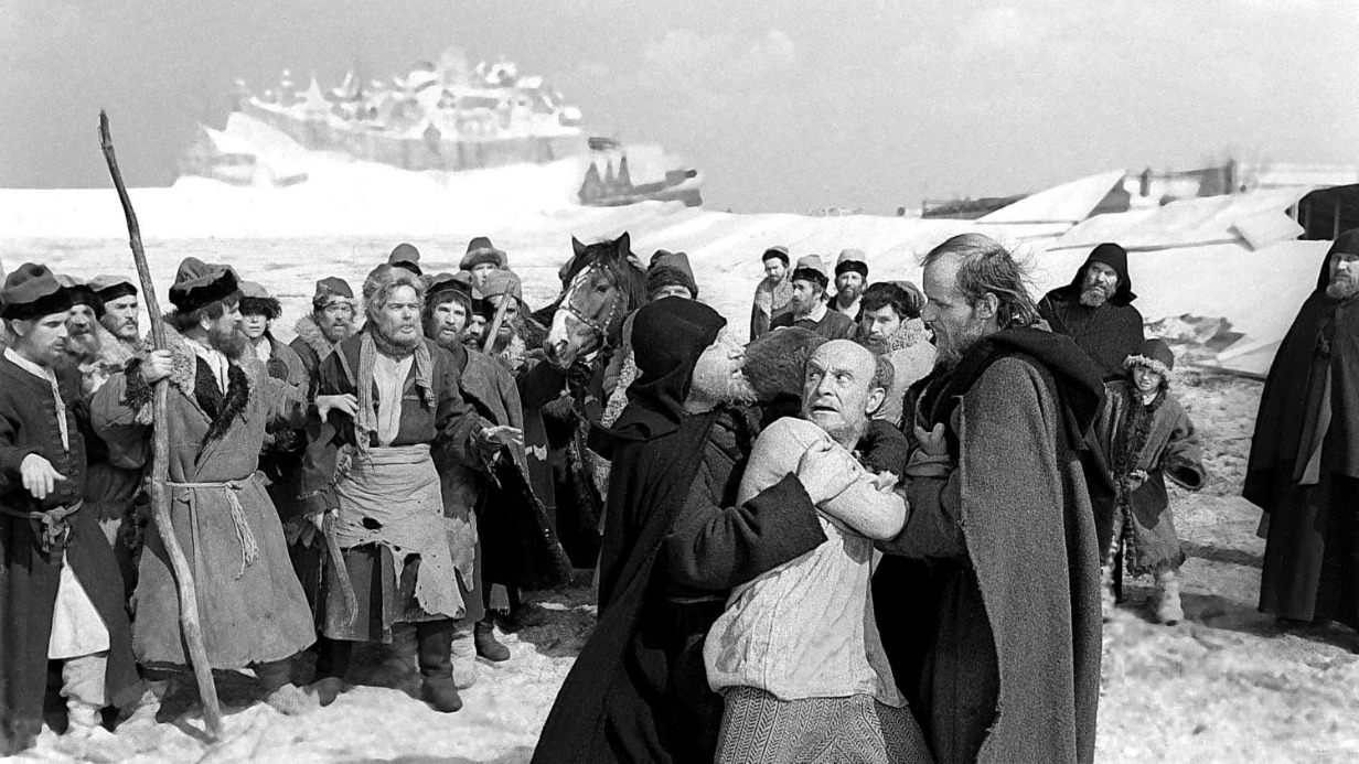 Кадр из «Андрея Рублева» (1966). Слева направо на переднем плане: Иван Лапиков в роли Кирилла удерживает скомороха (Ролан Быков) от обвинений Рублева (Анатолий Солоницын)