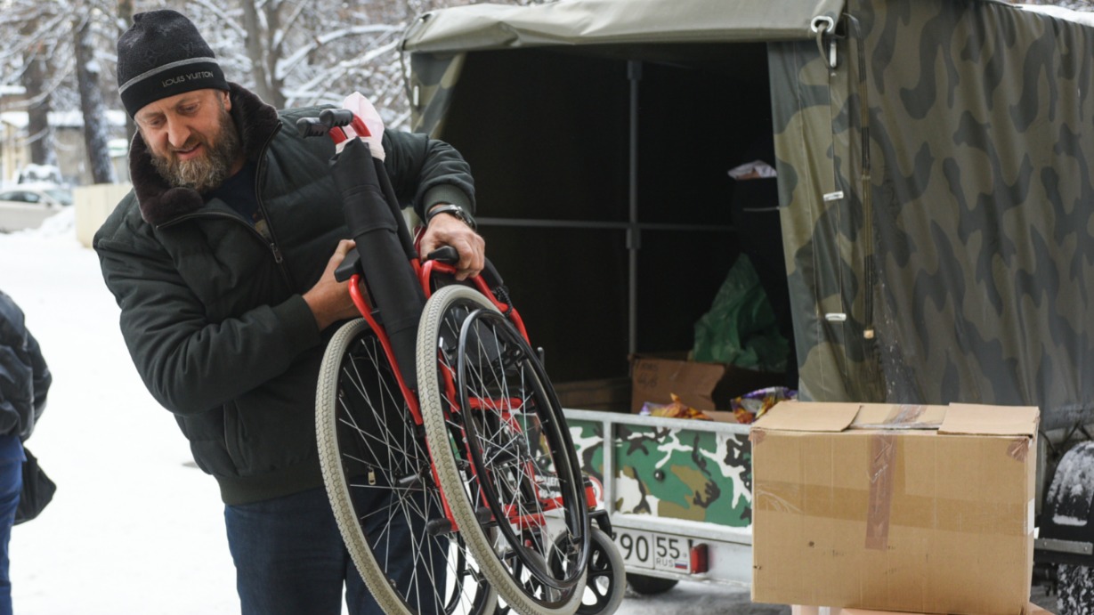 Вице-президент благотворительного фонда социальной поддержки и защиты граждан «Вечный зов» Евгений Гольман разгружает прицеп у отделения Госпиталя им. Бурденко. Кроме колясок, ребятам привезли и сладкие новогодние подарки, а также одежду, мобильные телефоны и многое другое