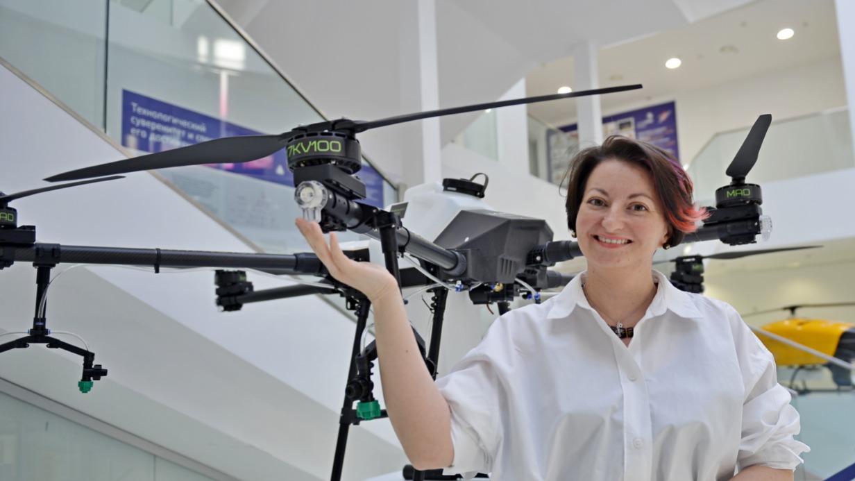Организатор форума-выставки «Первый беспилотный» Алина Яшина показывает гостям дрон, который можно использовать для опрыскивания сельскохозяйственных культур