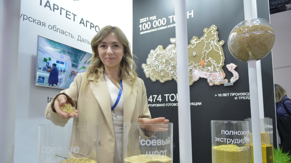 Ведущий менеджер отдела продаж компании по переработке соевых бобов Валентина Чернова на крупной агровыставке показывает продукцию. Отечественные товары Россия экспортирует дружественным странам, укрепляя рубль на мировом рынке