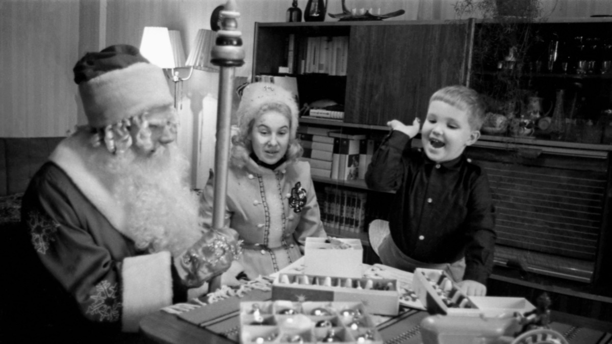 Дед Мороз и Снегурочка поздравляют с Новым годом юного москвича. Кстати, традиция дарить детям сладкие подарки зародилась именно в СССР