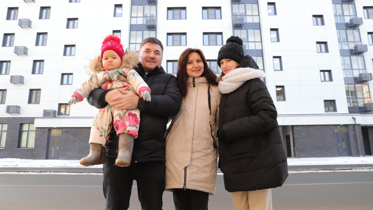 Ринат Исаев с супругой Румией, дочерьми Миланой и Сафией (на руках) на фоне нового дома, построенного в Южном Бутове на улице Краснолиманской, 29