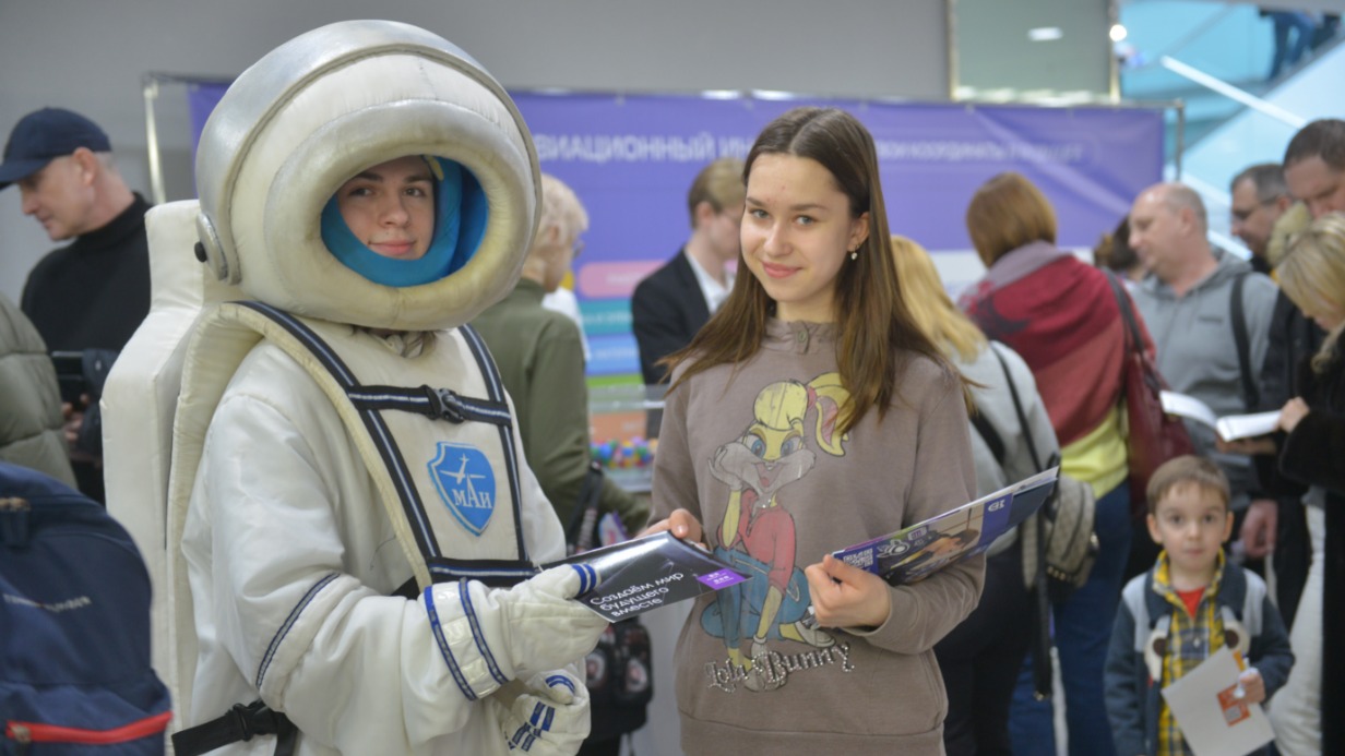 Студент Московского авиационного института Владислав Панчев на образовательной выставке «Навигатор поступления» в Центре международной торговли знакомит абитуриентку Анастасию Иванову с информацией по своему вузу