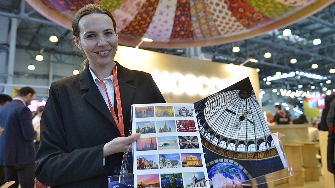 Екатерина Страхова на 29-й Международной выставке туризма и индустрии гостеприимства. Она демонстрирует гостям мероприятия каталог с самыми популярными местами столицы