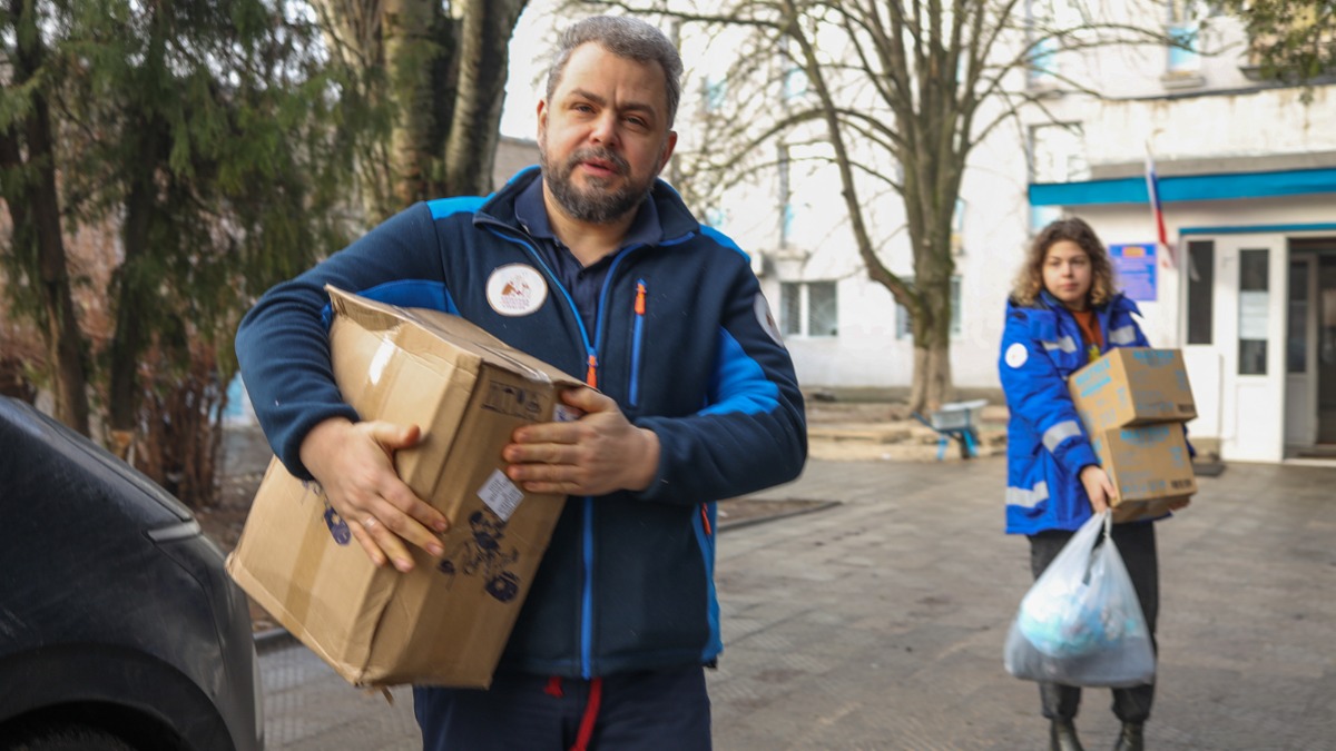 Главный врач больницы Святителя Алексия Алексей Заров несет коробки с гуманитарной помощью для медучреждений Донбасса