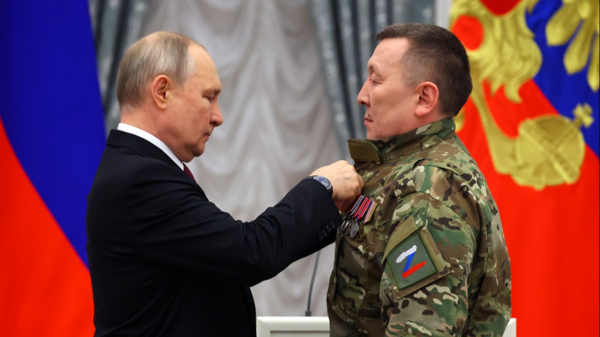 Президент России Владимир Путин (слева) вручает звезду Героя Российской Федерации добровольцу, заместителю командира 2-го отряда «Барс» Александру Колесову. Награждение прошло в Кремле