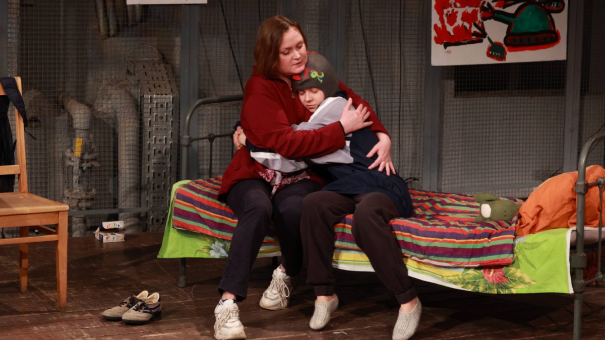 Инна (Анна Киреева) обнимает маленького Рому (Мария Швыдко) в подвале, где они оказались, потому что дом в Лисичанске был разрушен