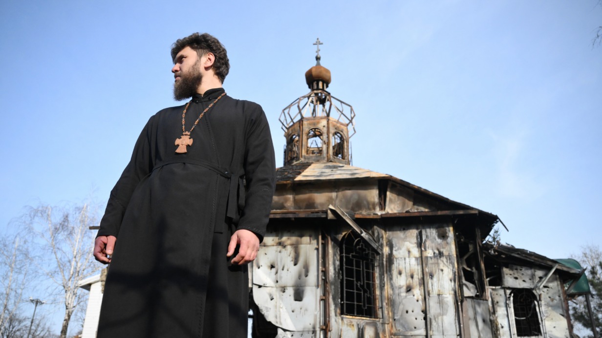 Отец Александр перед сгоревшим Свято-Преображенским храмом в Волновахе в ДНР в день празднования Входа Господня в Иерусалим