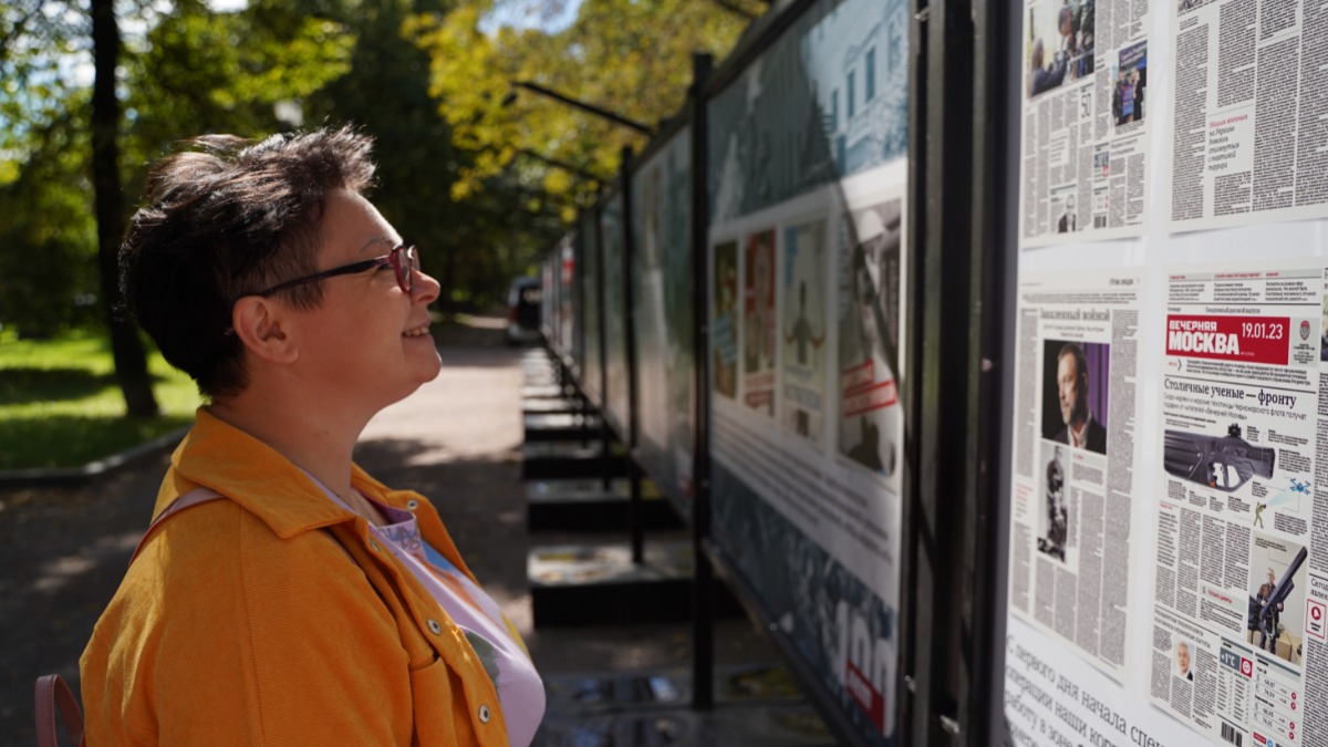 Жительница столицы Ольга Петрова рассматривает стенды фотовыставки «Наш век», посвященные «Вечерней Москве»