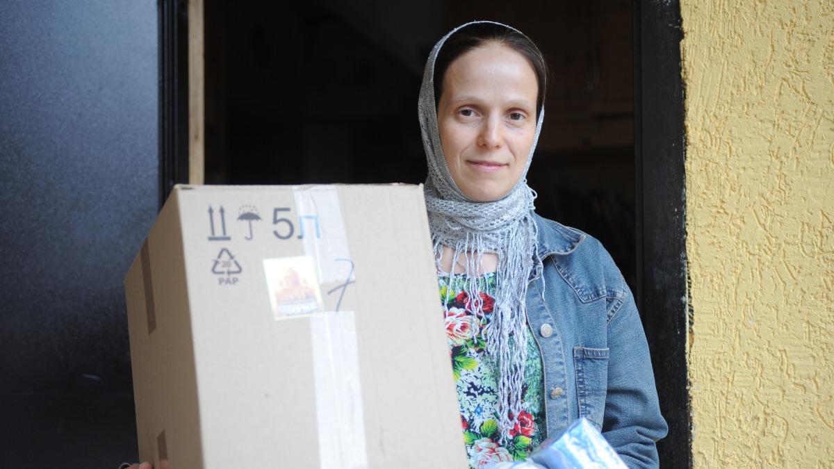 Социальный работник храма Преподобных Зосимы и Савватия в Гольянове Лилия Вострикова упаковывает гуманитарную помощь для беженцев