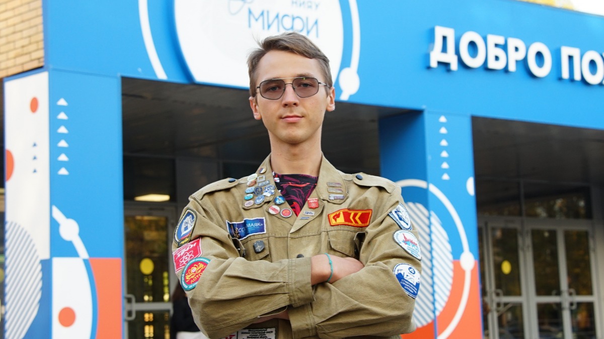 Участник международного студенческого строительного отряда «Лотос», студент НИЯУ МИФИ Станислав Пешков рядом с Национальным исследовательским ядерным университетом