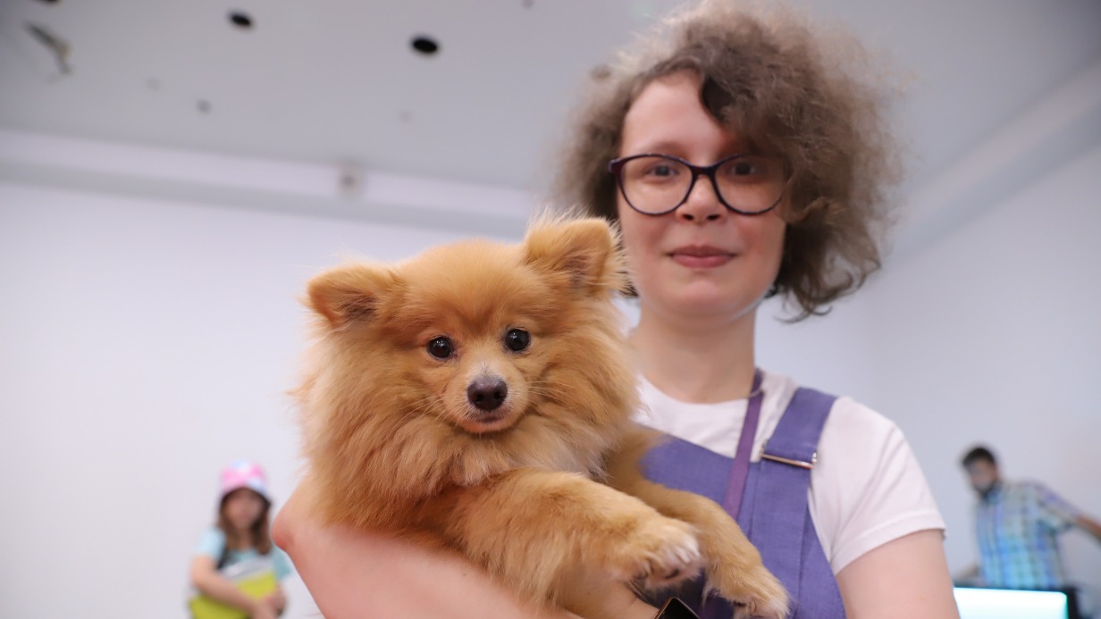 Жительница Южного округа Москвы Олеся Зубова со своим любимцем, шпицем по кличке Лис, на «Параде питомцев» в районном центре «Место встречи Ангара»