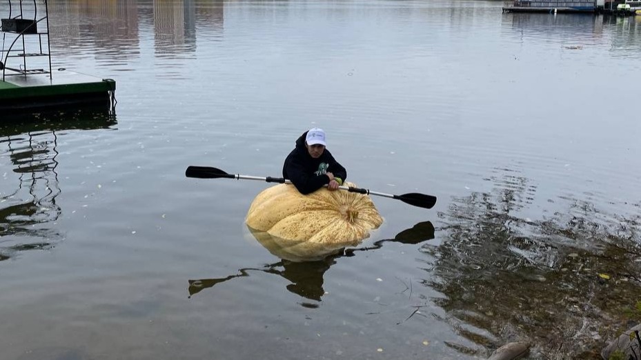 Фермер Гадель Хафизов во время своего оригинального заплыва по Моск ве-реке. В течение двух часов он сидел внутри тыквы, на коленях, управляя веслом 