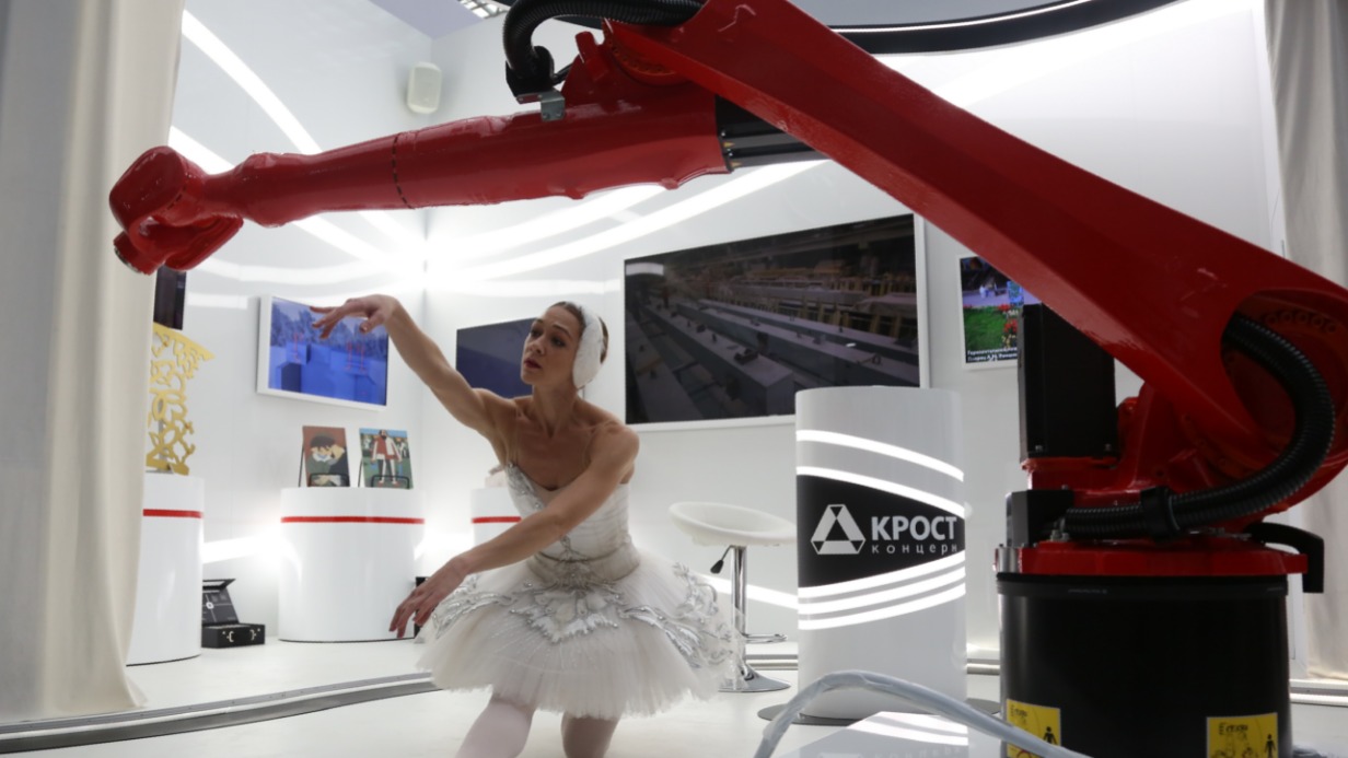 Балерина, артистка Большого театра Юлия Шошина танцует вместе с роборукой, принадлежащей одной из столичных компаний. Эта разработка помогает в изготовлении стеклофибробетона. Такой материал используется для облицовки поликлиник, его можно увидеть и в парке «Зарядье», и в арт-объектах столицы
