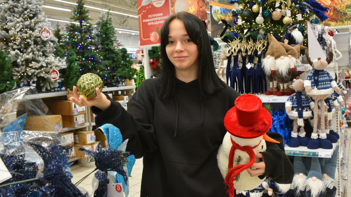 Студентка Виктория Кореш на новогоднем базаре выбирает праздничные украшения 