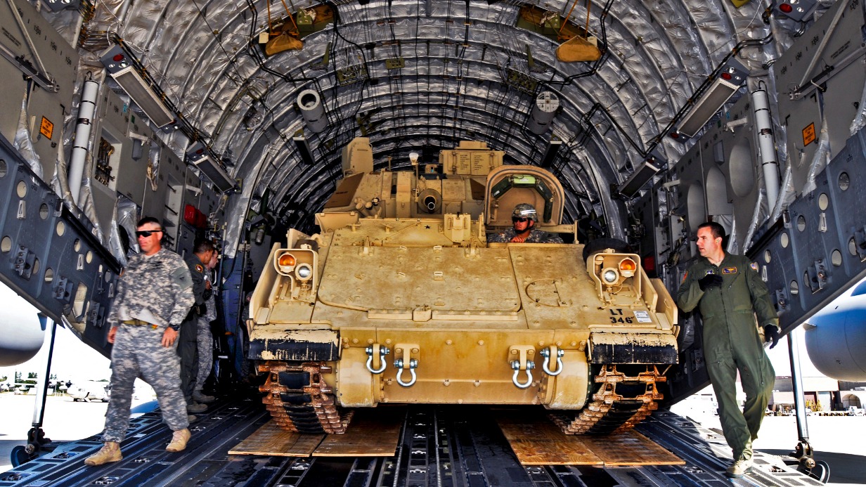 Боевую машину Bradley грузят в транспортный самолет. Точно такие же машины президент США Джо Байден отправил на Украину