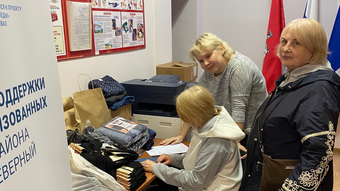 Благотворители Светлана Малько (слева) и Галина Харлан и сотрудник администрации МО Северный Светлана Терехова (на заднем плане) готовят к отправке очередную партию теплых вещей для нужд фронта