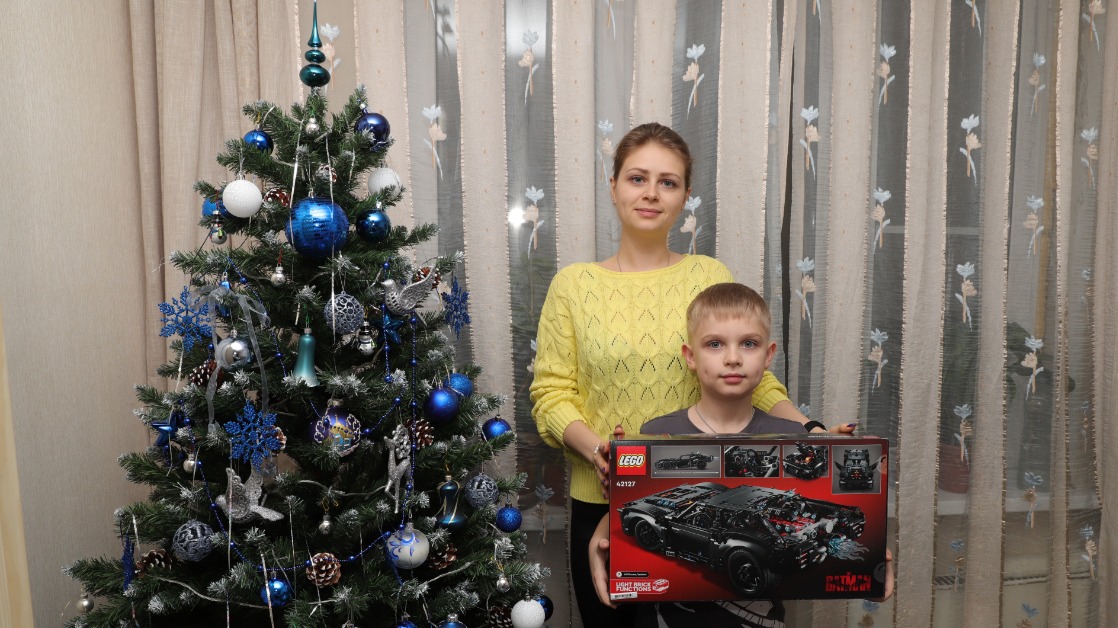 Жена погибшего героя СВО Анастасия Раихина вместе с сыном Артемом. Ребенок получил конструктор, который очень хотел. Детскую мечту исполнили благодаря акции «Елка желаний»