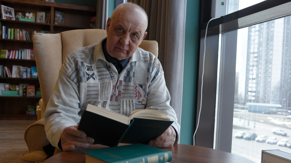 Московский пенсионер Виталий Иванов проводит время за чтением книг 