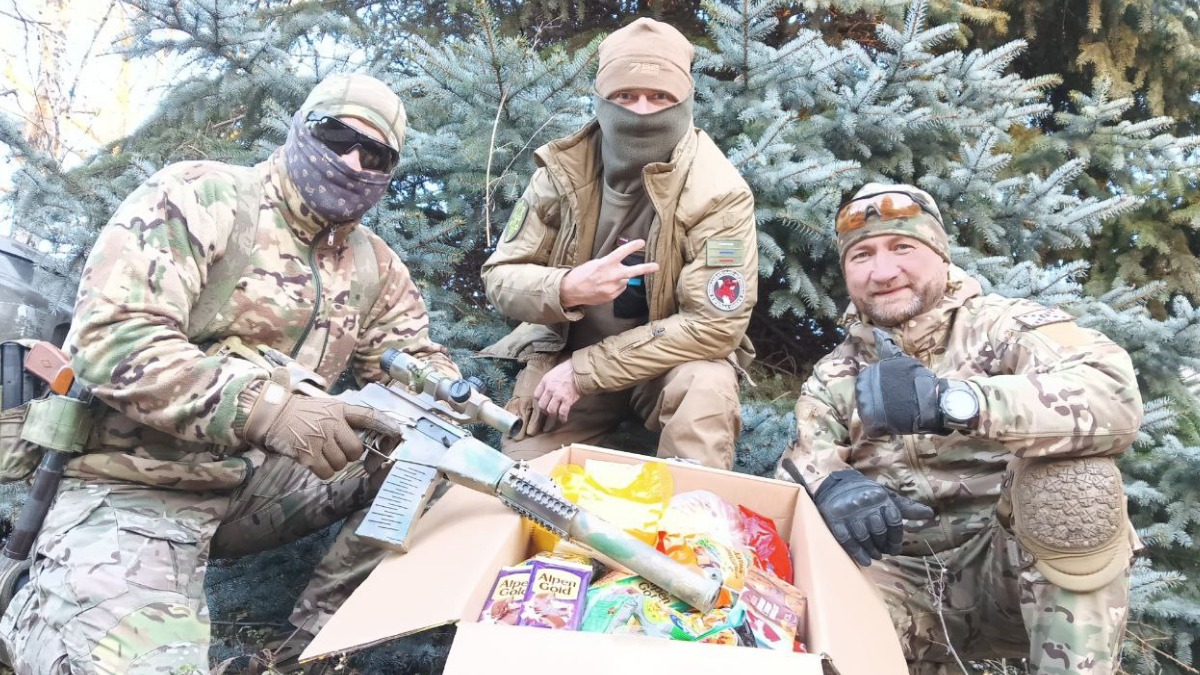 Военнослужащие отряда «Волки»: боец с позывным «Гурон», заместитель командир отряда с позывным «РАВ» и боец с позывным «Шуня» (слева направо) в Донецкой Народной Республике с коробкой новогодних подарков