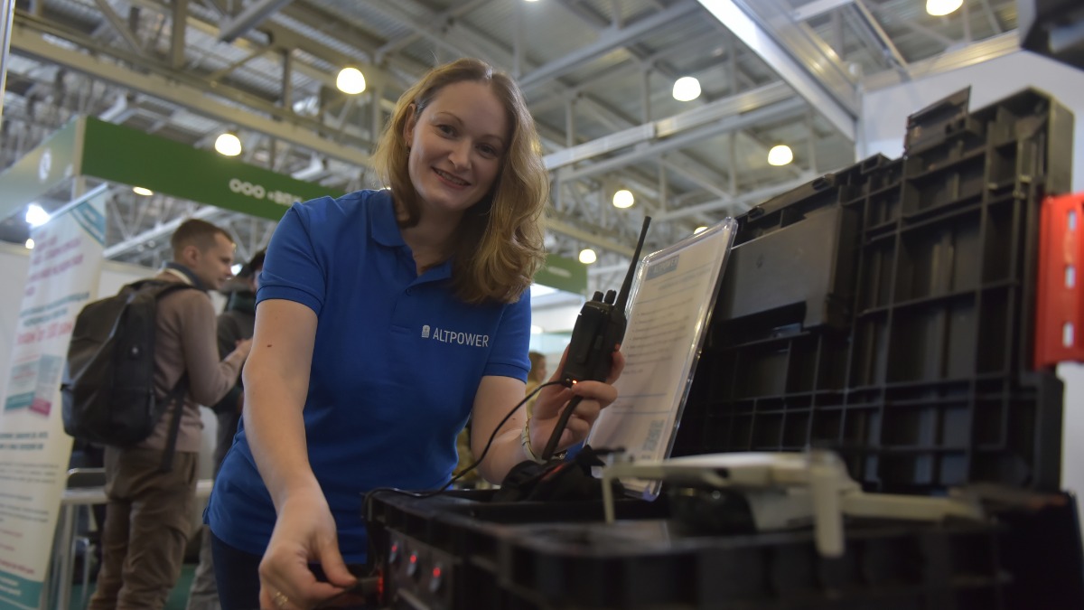 Участница Форума содействия СВО «Плечом к плечу» Мария Жигунова показывает посетителям разработку их компании — солнечную мобильную электростанцию