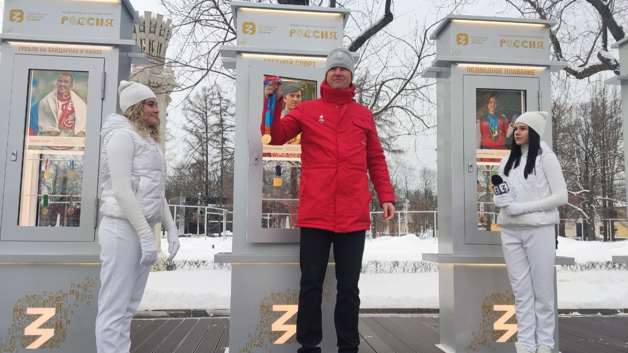 Олимпийский чемпион по гребле Алексей Свирин (в центре) передает свою медаль для Аллеи Славы