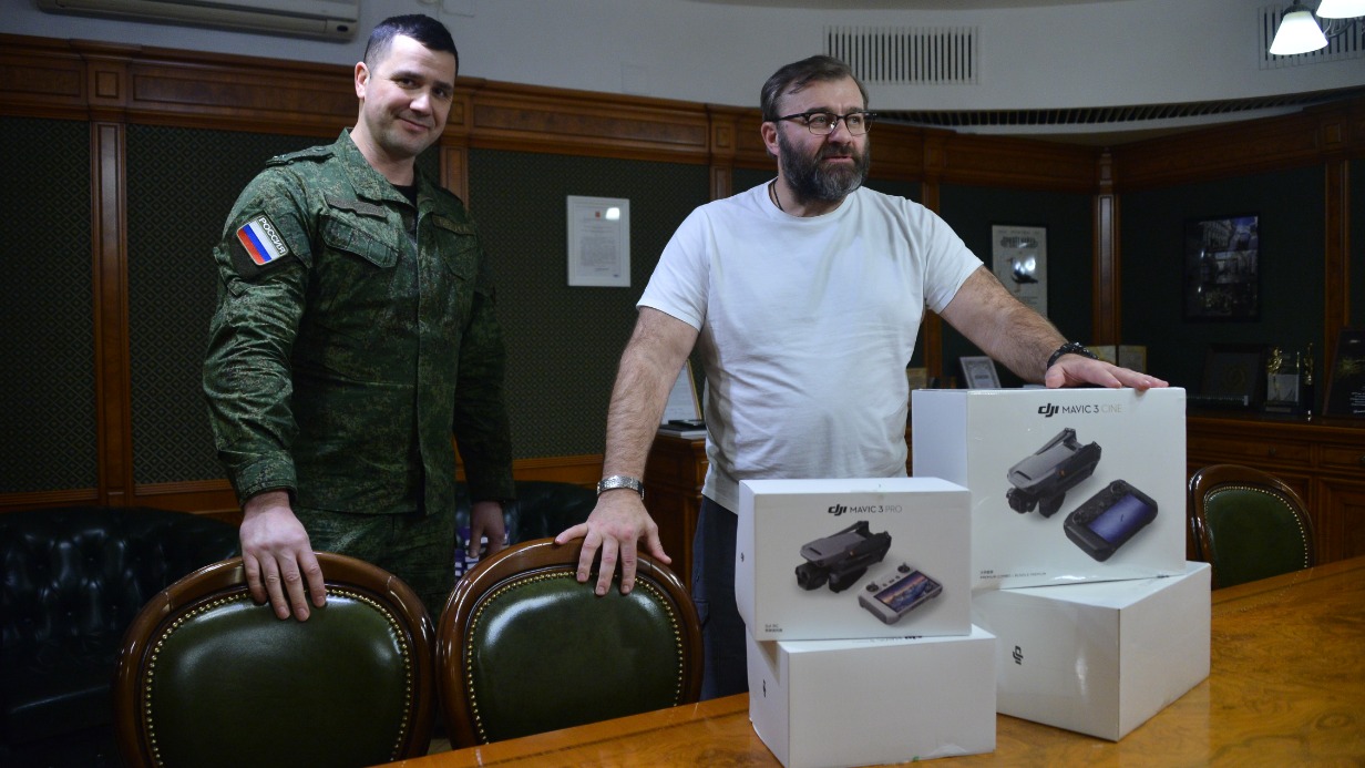 Народный артист РФ Михаил Пореченков (справа) передает квадрокоптеры заместителю командира роты 32-го мотострелкового полка Антону Зеленову в Московском художественном театре имени А. П. Чехова
