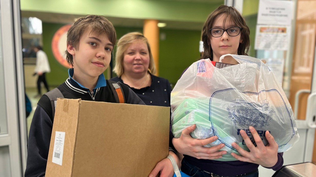 Ученики 7-го класса школы № 1164 Михаил Чихачев (слева) и Даниил Мальсагов вместе с классным руководителем Наталией Серенко принесли в школу коробки с влажными салфетками для бойцов